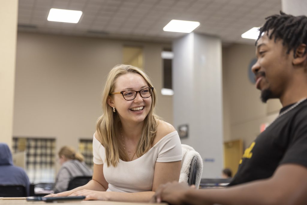 Students talking at table. 
