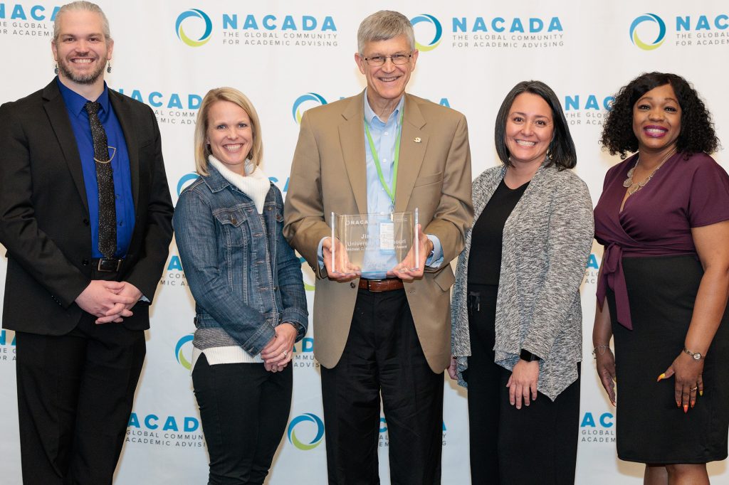 Dr. Jim Spain holding an advising award. 